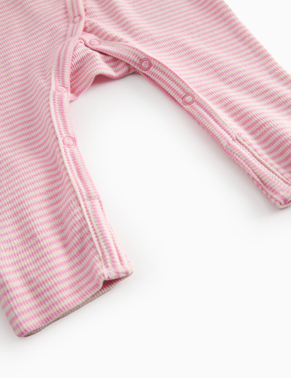 Langærmet baby heldragt with lyserøde striber and slå-om-lukning

Translation:
Long-sleeved baby onesie with bright red stripes and a flip-over closure