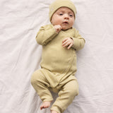 Baby wearing a long-sleeved sweater with green stripes and a front closure, along with a matching hat.
