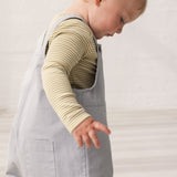 Children wearing green striped bodies under gray overalls.