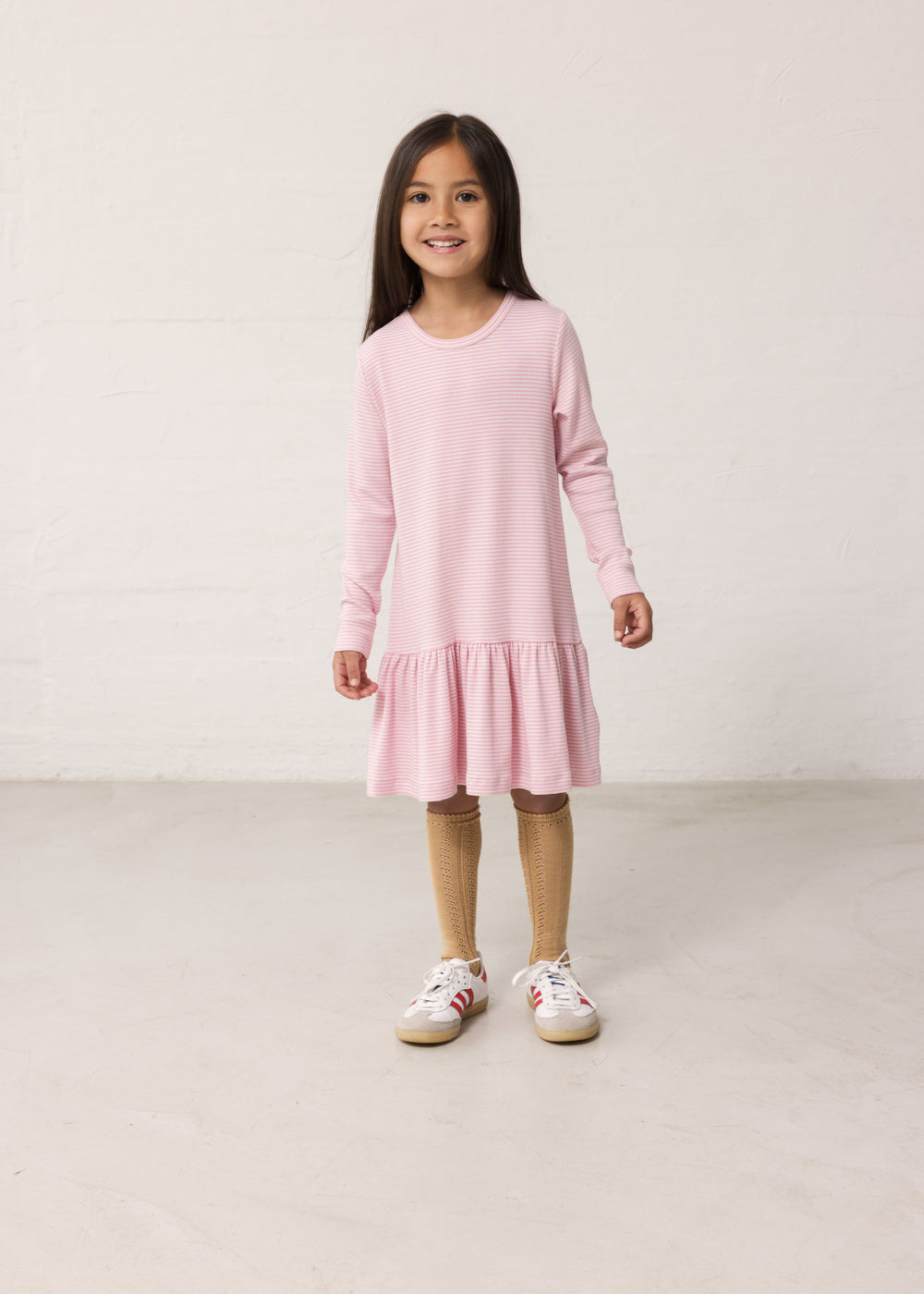 Child wearing a striped dress with long sleeves.