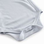 Langærmet lyseblå bodystocking til nyfødte med slå-om-lukning