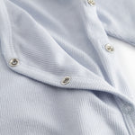 Lyseblå langærmet heldragt med slå-om-lukning til nyfødte