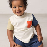Baby wearing a raw white T-shirt with contrast sleeves and pocket.