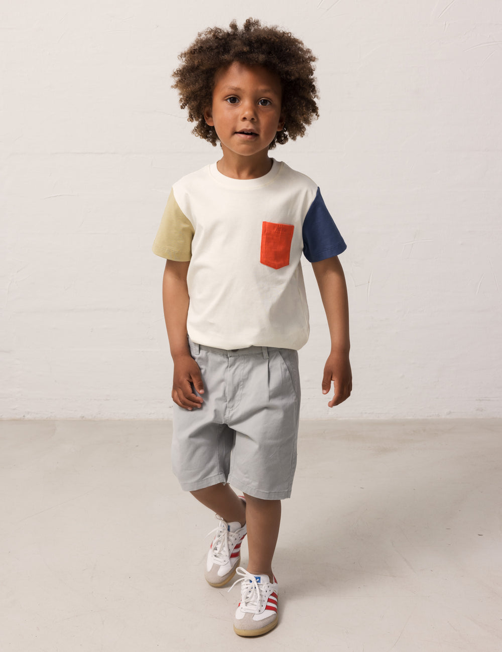 Children wearing a white T-shirt with contrast sleeves and a pocket.