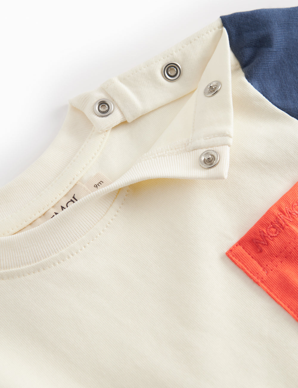 Short-sleeved baby T-shirt in raw white with contrasting sleeves and chest pocket.