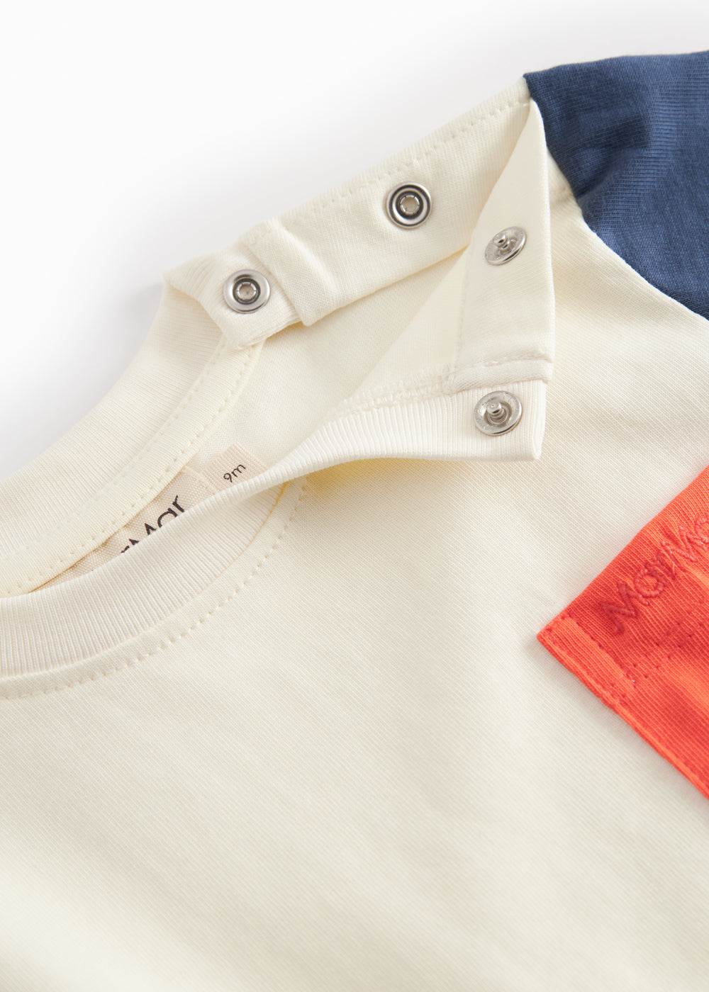 Short-sleeved baby T-shirt in raw white with contrasting sleeves and chest pocket.