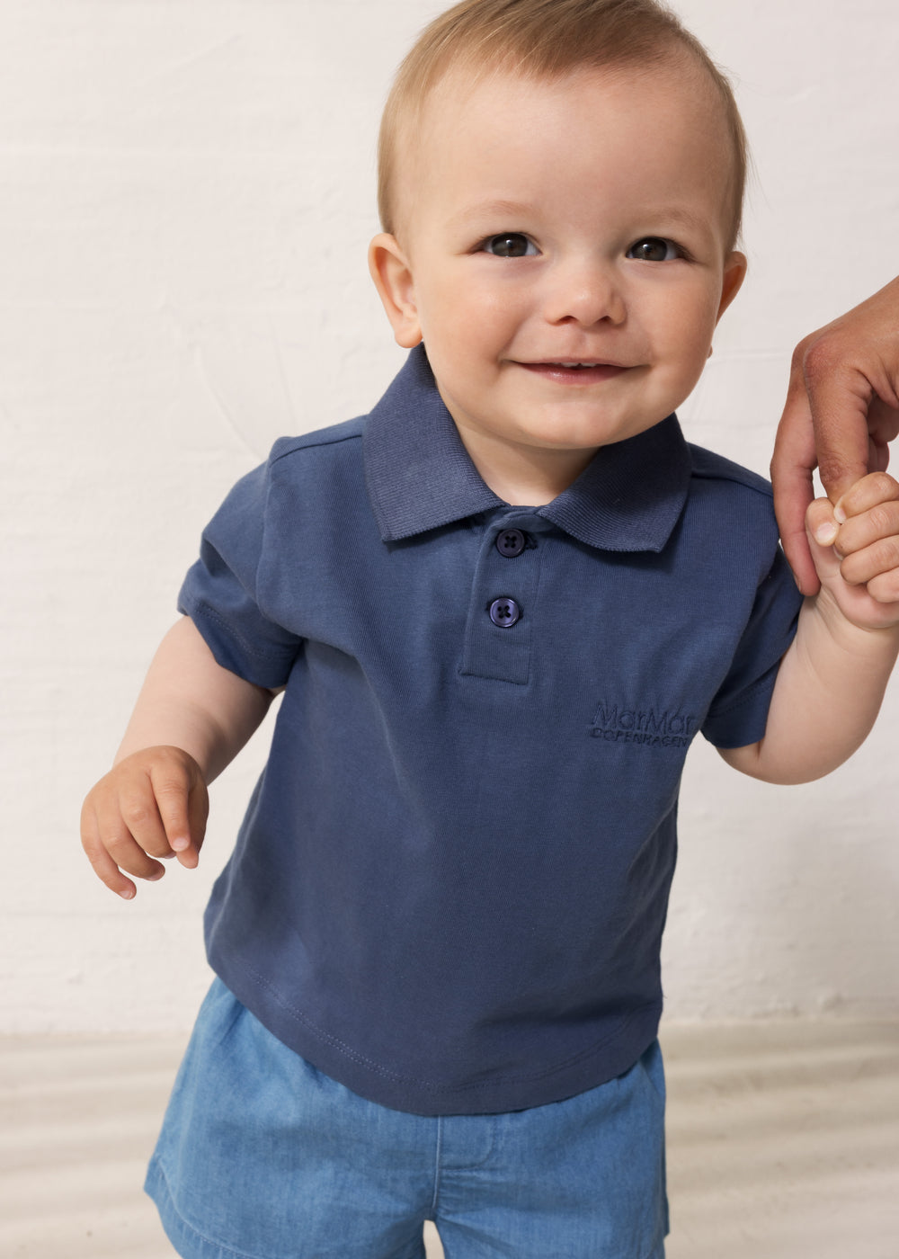 Baby wearing short-sleeved blue polo t-shirt with collar and button-up