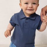 Baby wearing short-sleeved blue polo t-shirt with collar and button-up