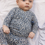 Baby wearing blue long-sleeved leopard bodystocking for newborns