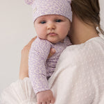 Baby wearing a knitted leopard hat with ears and matching outfit.