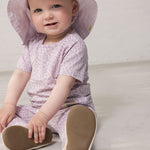 Baby wearing a light lavender summer hat and a lavender leopard-patterned outfit.