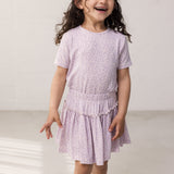 Child wearing a purple t-shirt and pants.