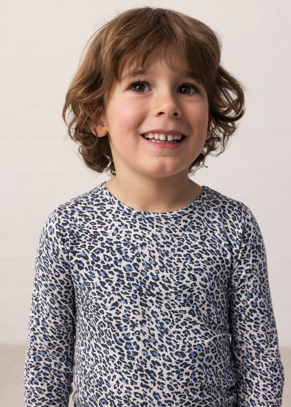 Boy wearing a blue long-sleeved leopard t-shirt