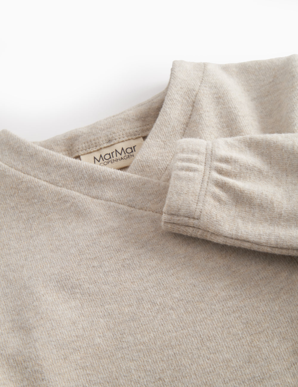 Beige sweatshirt for baby with diagonal button closure.
