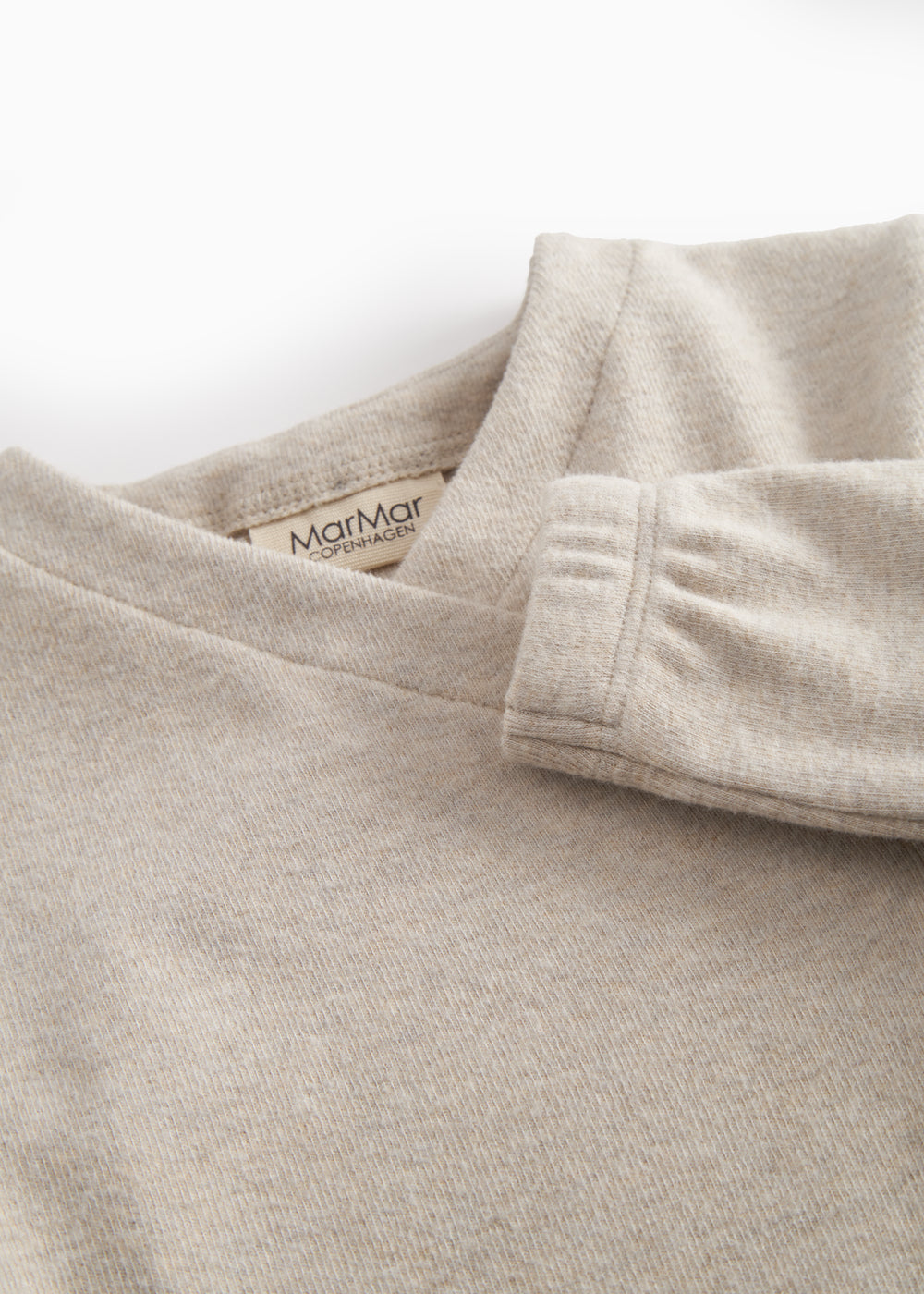 Beige sweatshirt for baby with diagonal button closure.