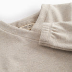 Beige sweatshirt for baby with diagonal button closure.