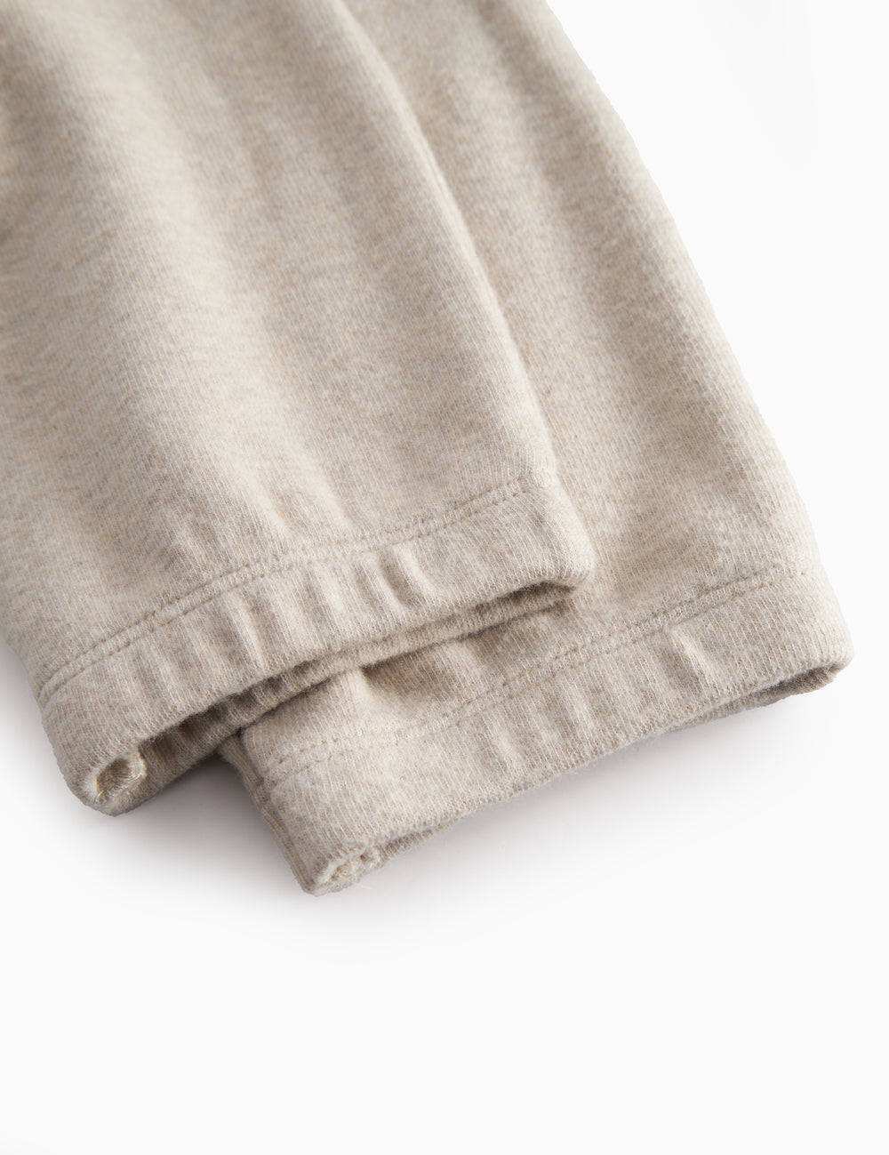 Beige sweatshirt for baby with diagonal button closure.