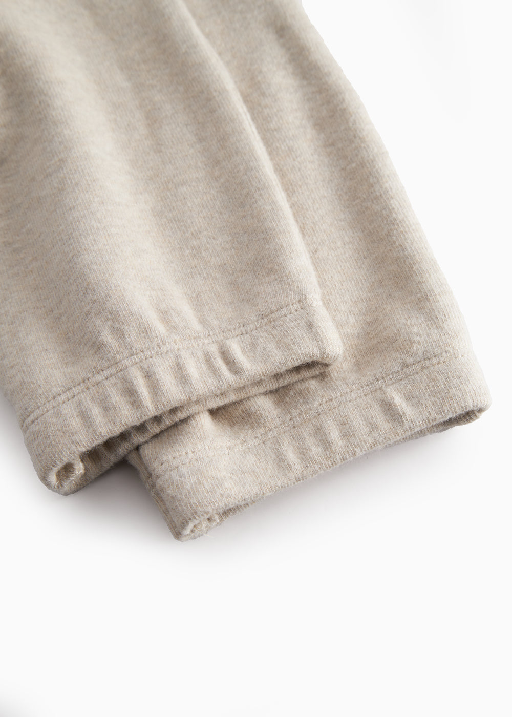 Beige sweatshirt for baby with diagonal button closure.