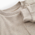 Beige baby onesie with ribbing on the neck, sleeves, and legs.