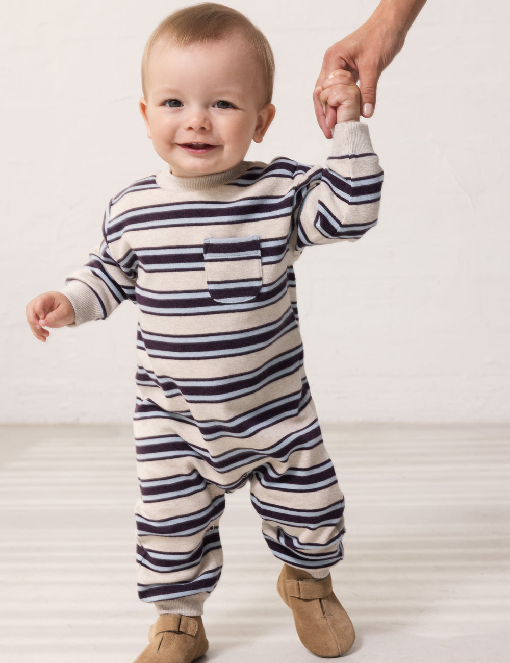 Baby wearing a long-sleeved striped sweater with ribbing in the neck, sleeves, and legs.