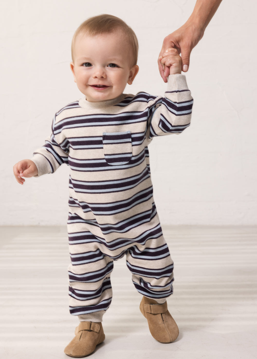 Baby wearing a long-sleeved striped sweater with ribbing in the neck, sleeves, and legs.