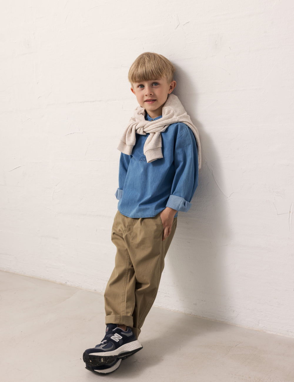 A child wearing a blue shirt and green pants.