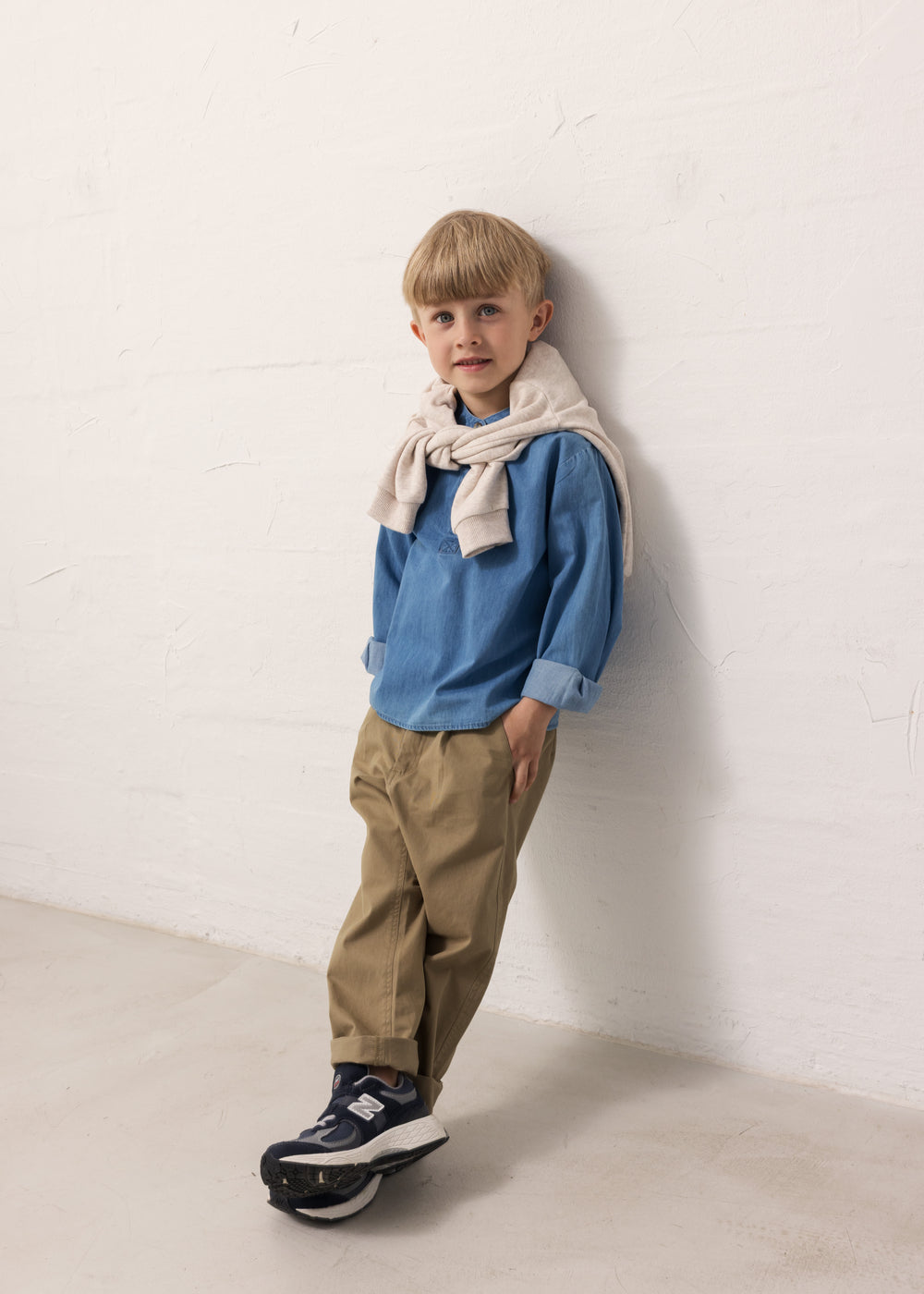 A child wearing a blue shirt and green pants.