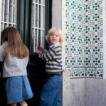 To children wearing striped sweat polo shirts and denim clothing.