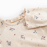 Langärmet baby bodystocking with floral print and snap closure