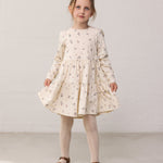 Wearing a long-sleeved layered dress with a floral print.