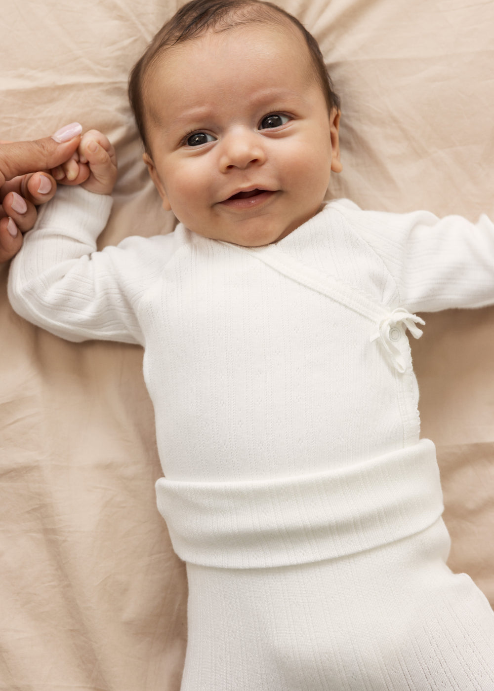 Baby wearing white pinstripe pants and a body