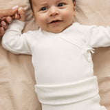 Baby wearing white piqué pants with feet and body
