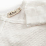 Fleece pointelle blouse for newborns with a wrap-around closure.
