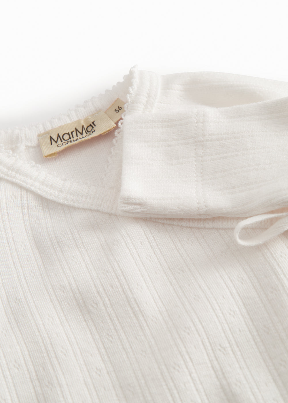 White long-sleeved pointelle onesie with a snap closure for newborns