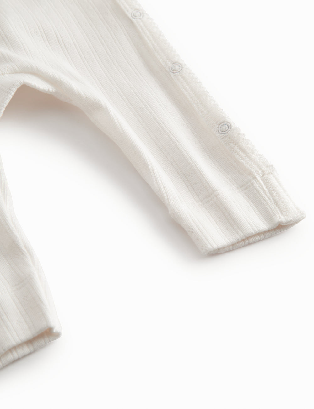 White long-sleeved pointelle onesie with a snap closure for newborns
