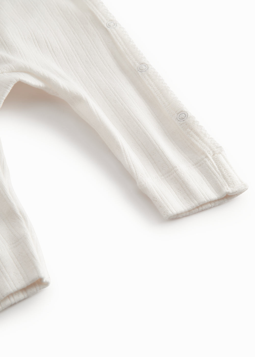 White long-sleeved pointelle onesie with a snap closure for newborns