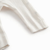 White long-sleeved pointelle onesie with a snap closure for newborns