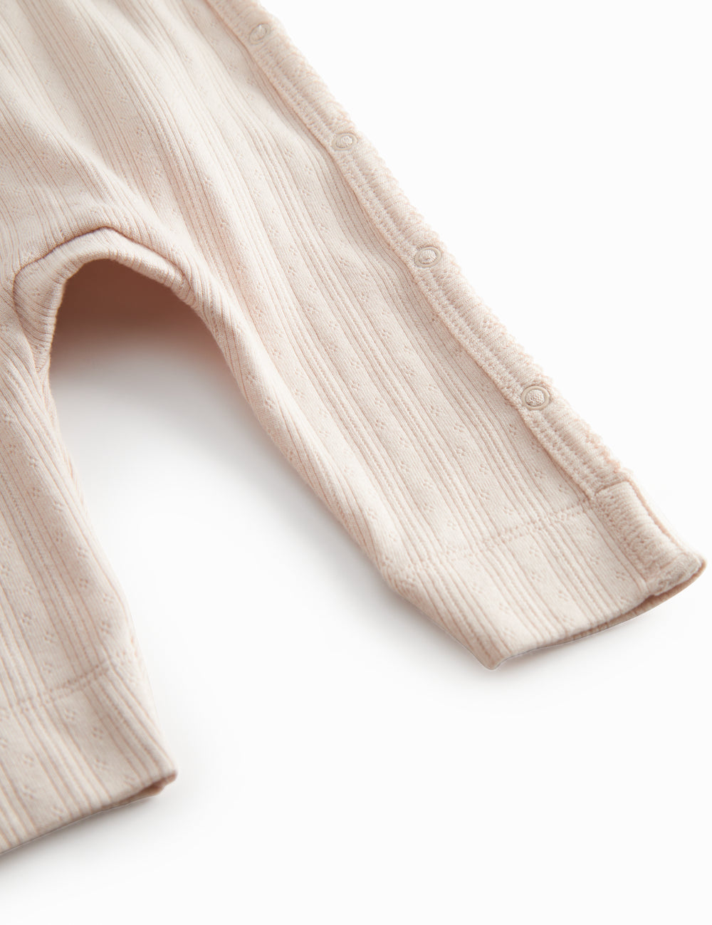 Red long-sleeved pointelle onesie with a front closure for newborns.