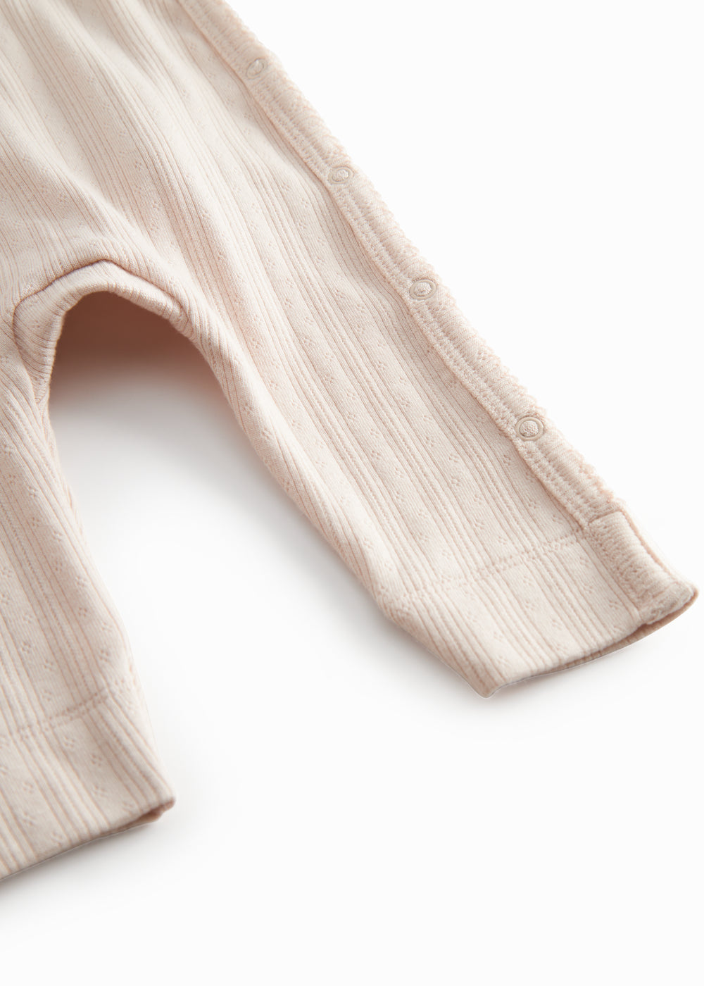 Red long-sleeved pointelle onesie with a front closure for newborns.