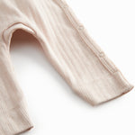 Red long-sleeved pointelle onesie with a front closure for newborns.