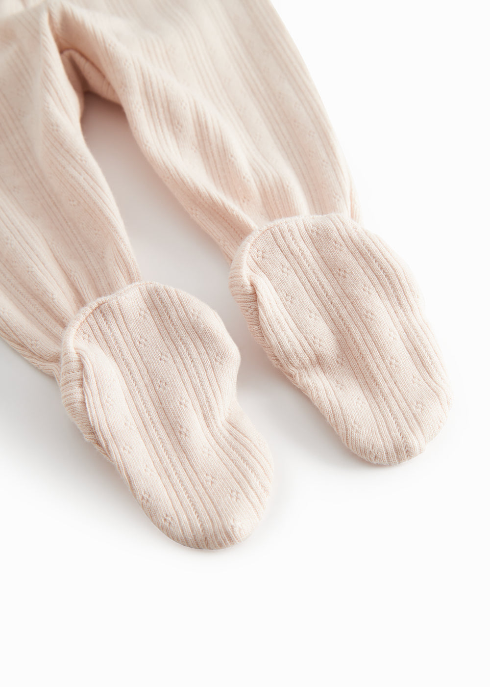 Red polka-dot pants with feet for a newborn baby.