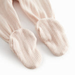 Red polka-dot pants with feet for a newborn baby.