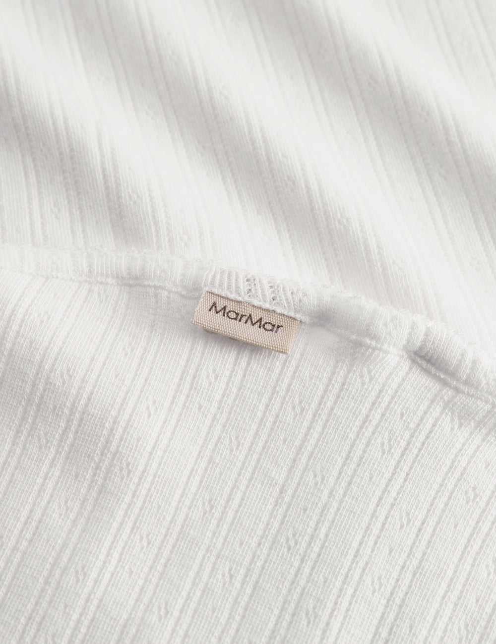 White cotton baby blanket with rounded corners and picot edges.