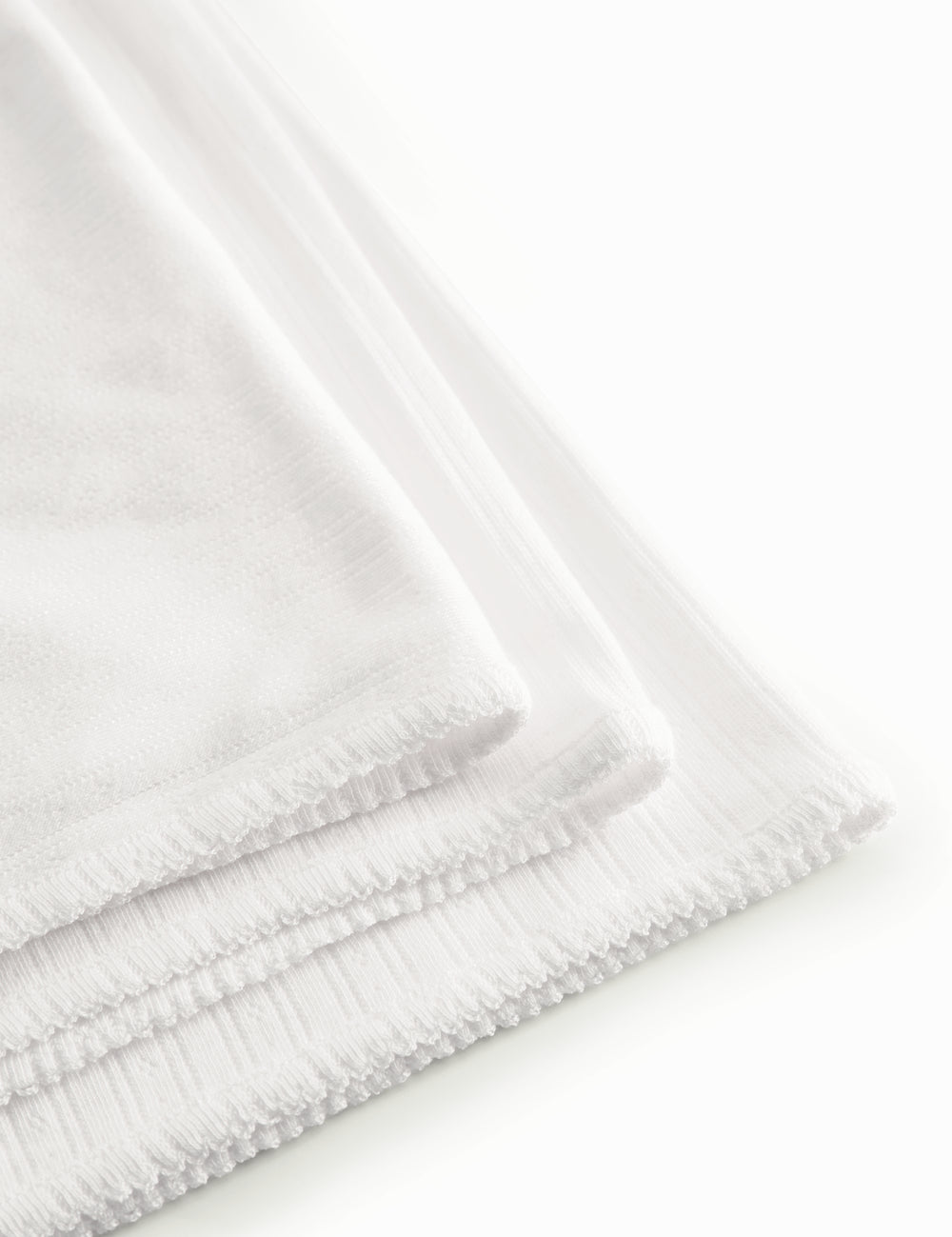 White cotton baby blanket with rounded corners and picot edges.