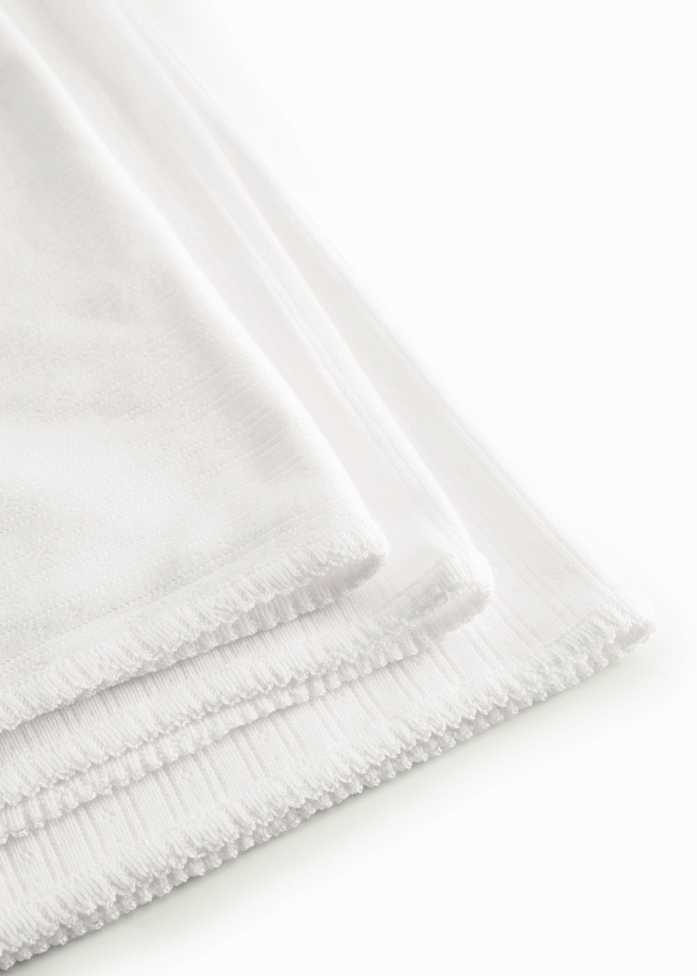 White cotton baby blanket with rounded corners and picot edges.