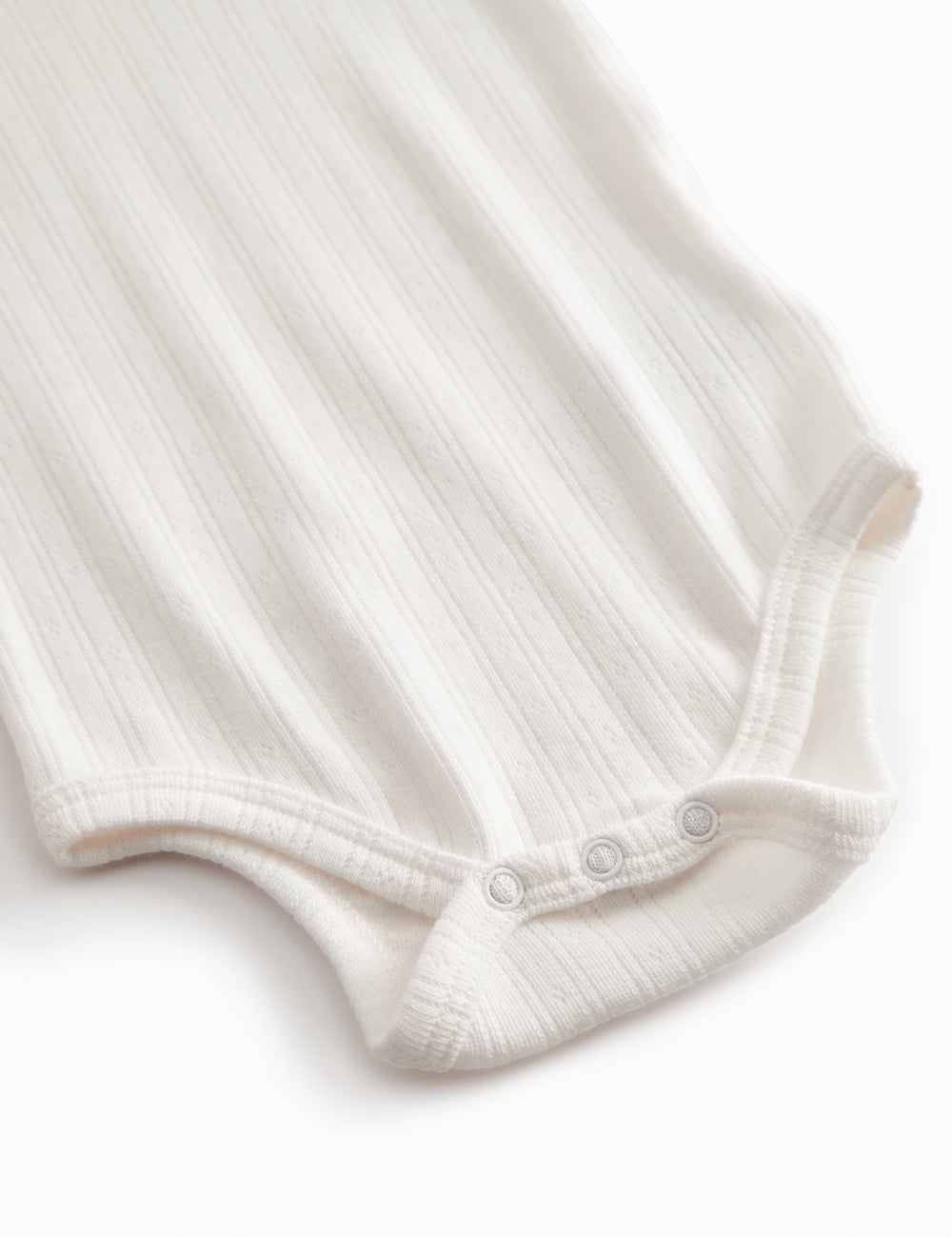 Langærmet hvid pointelle baby bodystocking