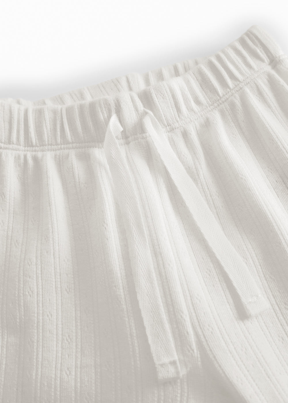 White pinstripe baby pants with elastic and a decorative band at the waist.
