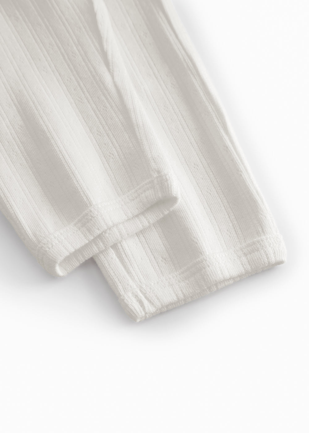 White pinstripe baby pants with elastic and a decorative band at the waist.