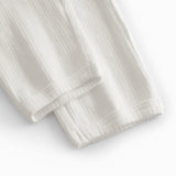 White pinstripe baby pants with elastic and a decorative band at the waist.
