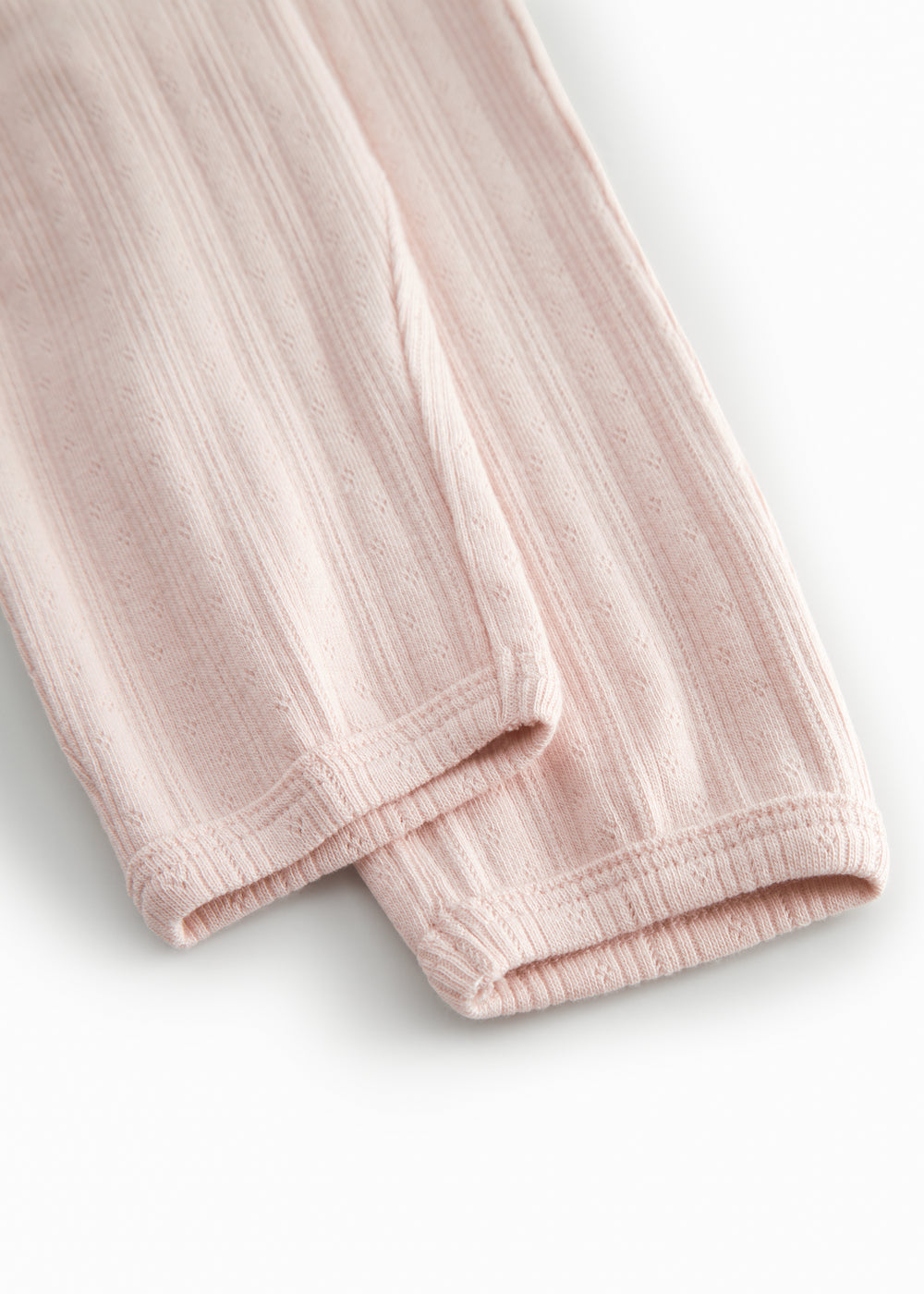 Red polka-dot baby pants with elastic and a decorative band at the waist.